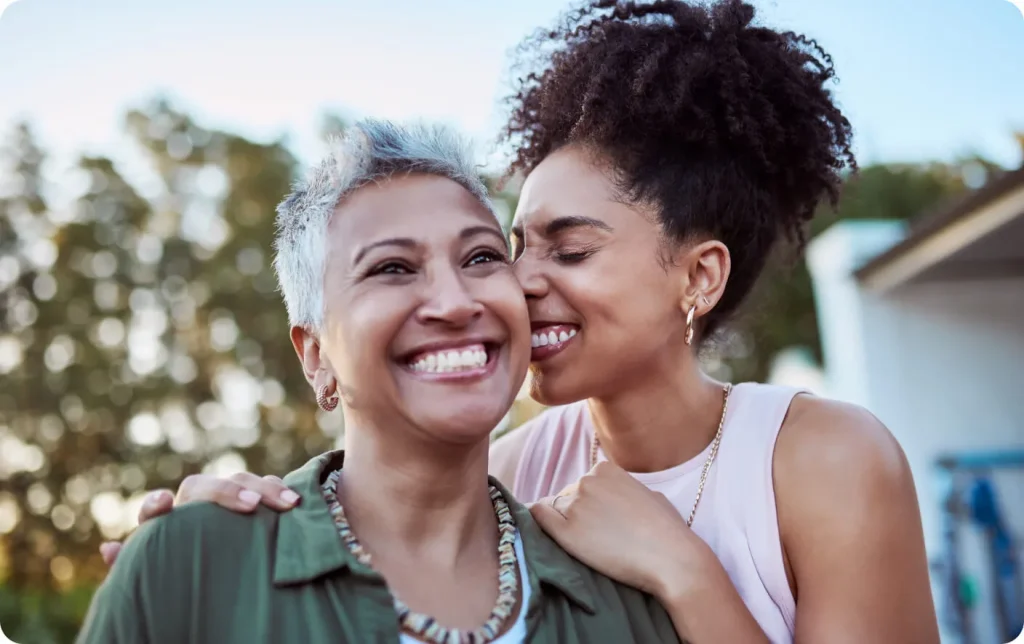 Two women hug and smile